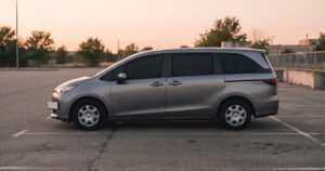 夕暮れの駐車場に停まるミニバンの側面、窓という窓に目隠しシェードが取り付けられている様子